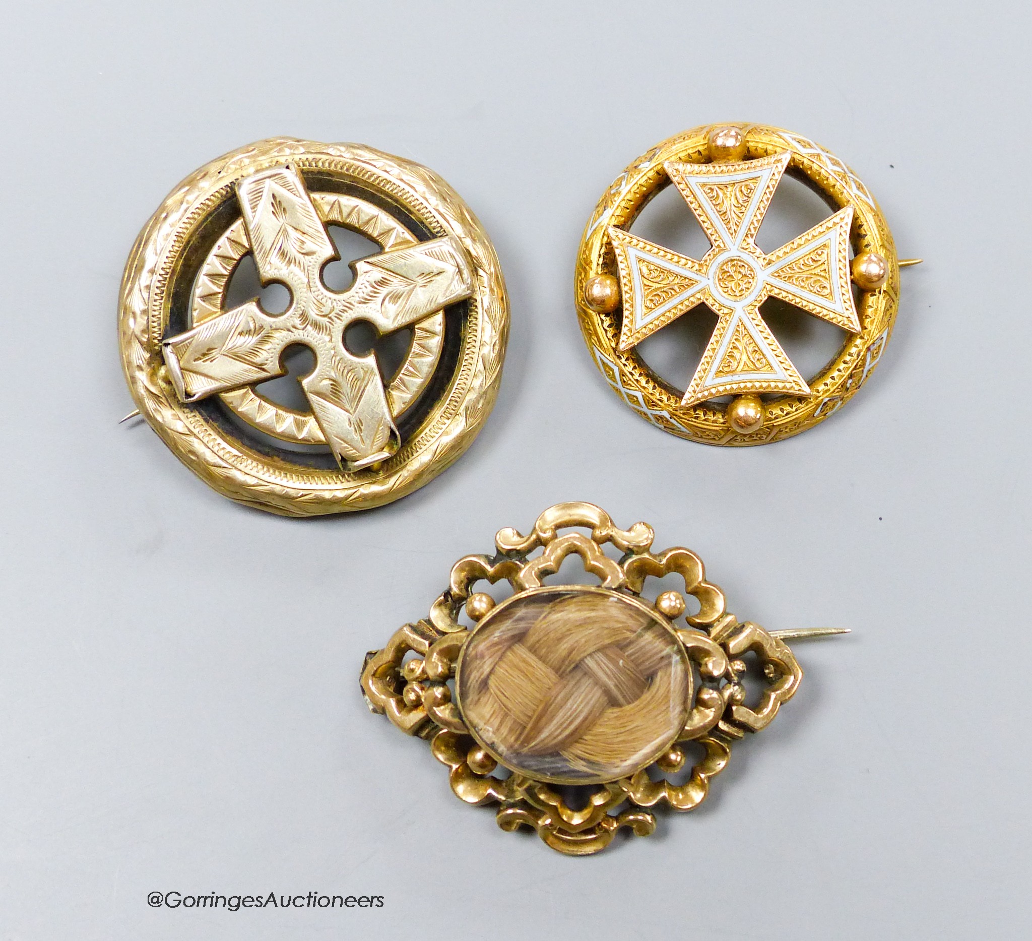 A Victorian yellow metal and enamel brooch, with central cross motif, 31mm and two other brooches including mourning.